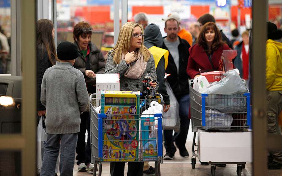 Customers leave store with their purchased items. (Photo by Joshua Lott/Getty Images)